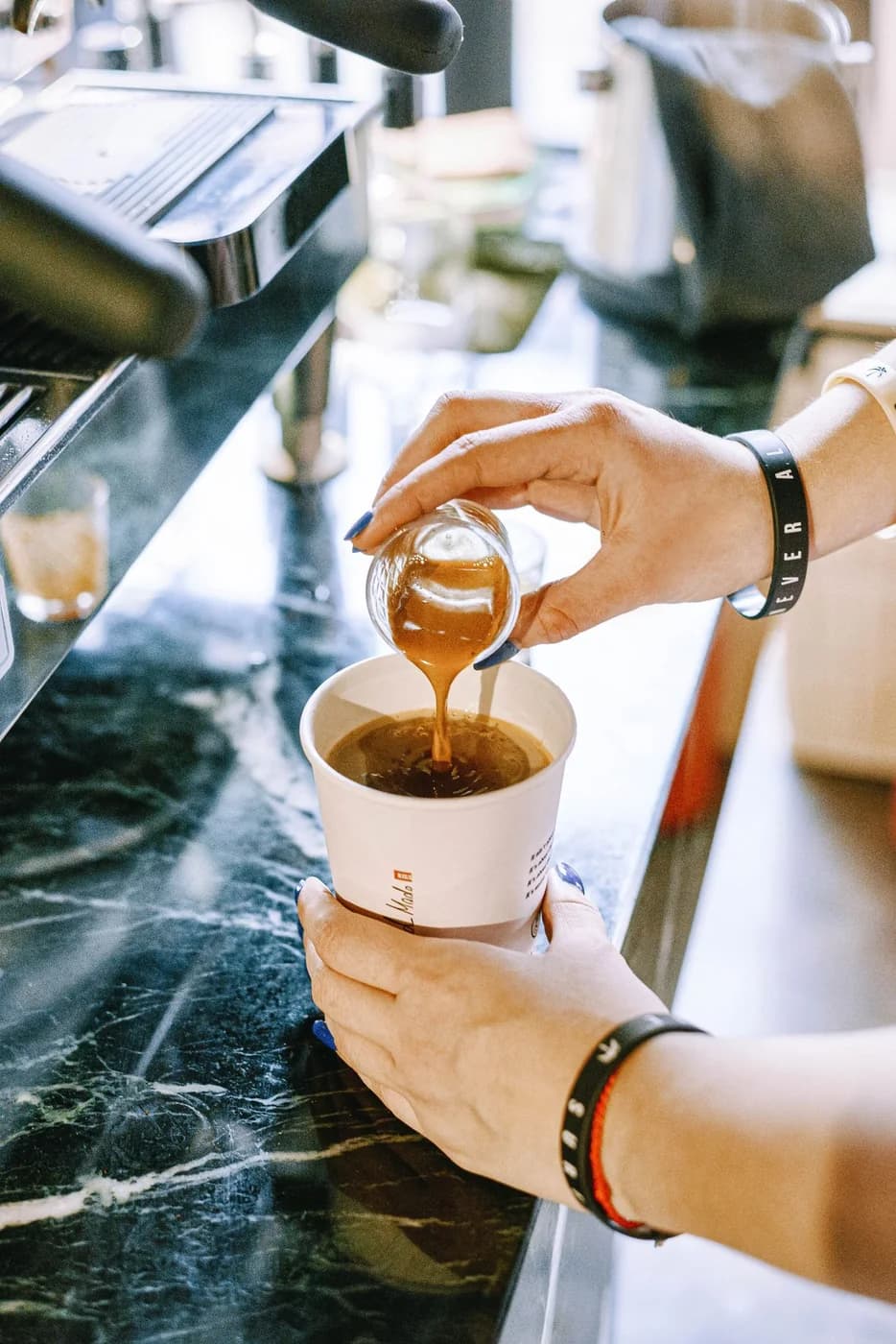 Fresh espresso shot poured into a paper cup at a mobile coffee bar